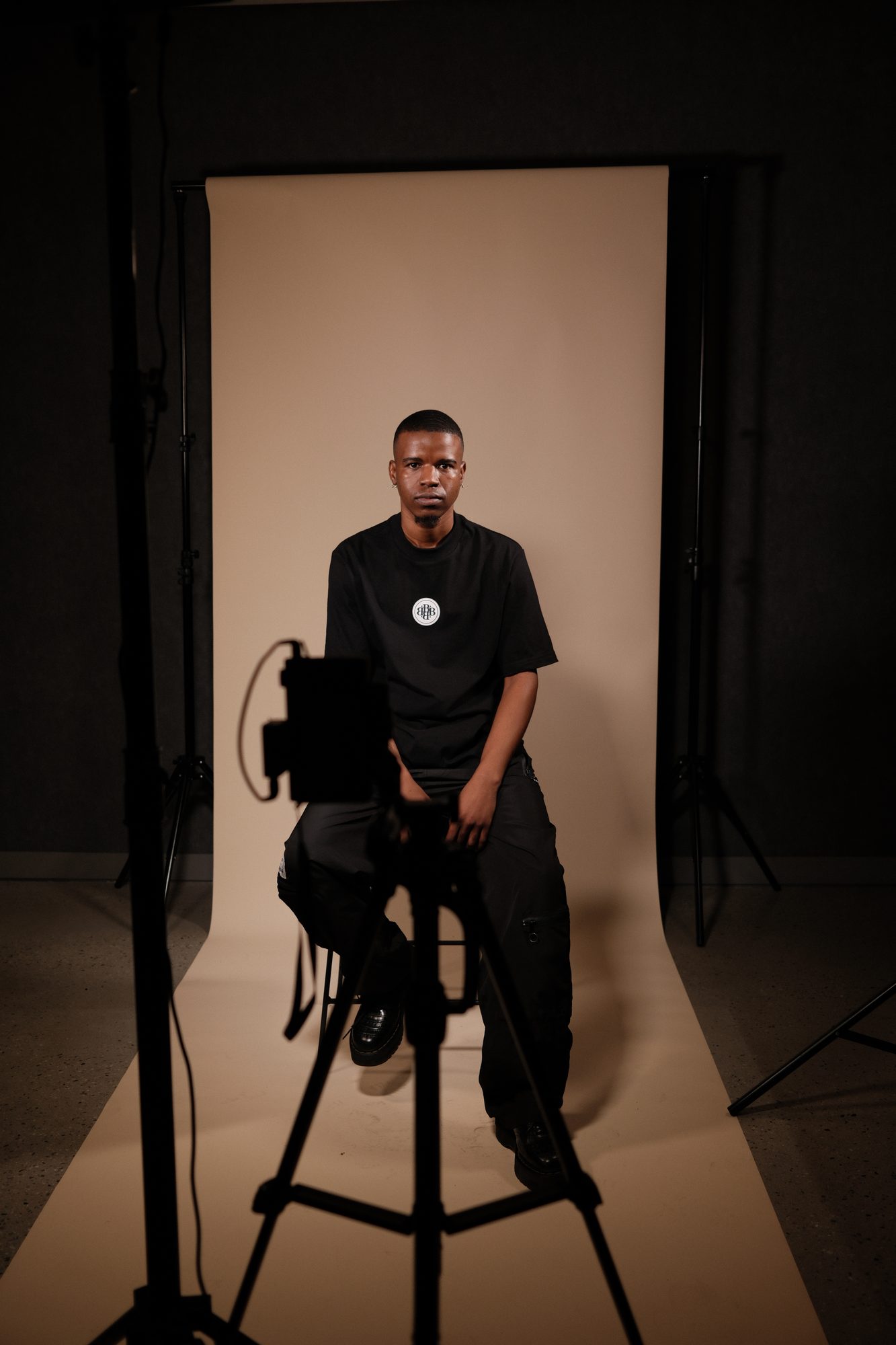 An interviewee seated on a stool in a rented studio